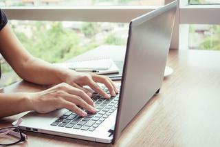 Laptop with hands typing on the keyboard