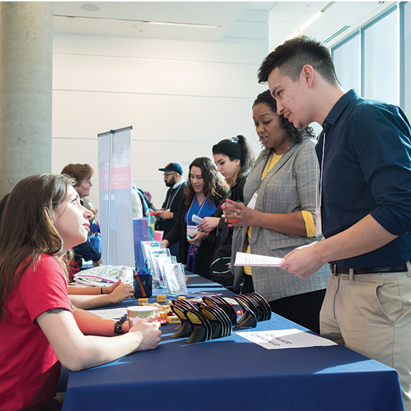 A student taking to a person talking to a recruiter at a table