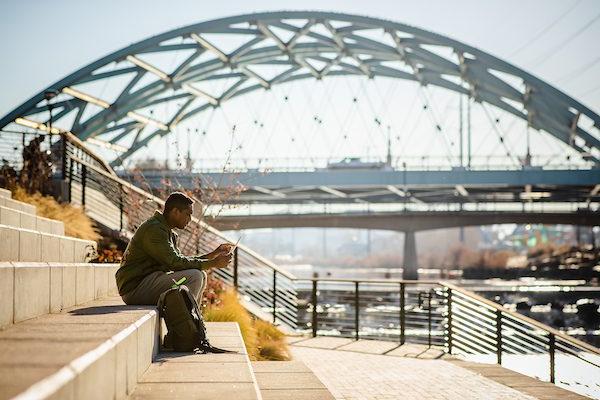 Student with laptop outside at Confluence Park in Denver