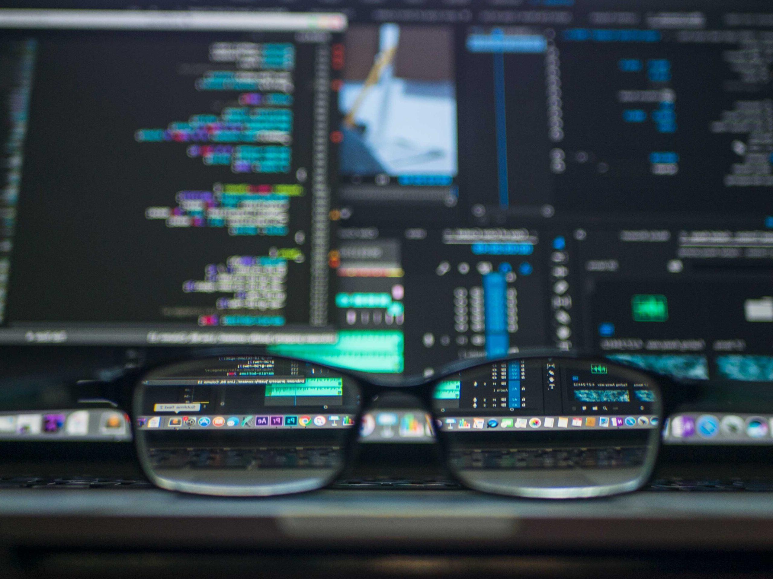 a glass with coding screen in the back