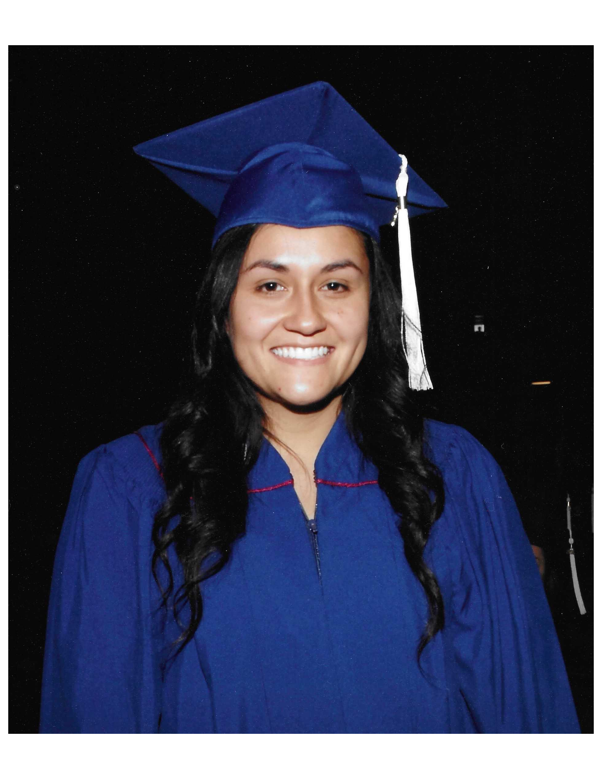 Isabel Corona Guevara smiles in her cap and gown